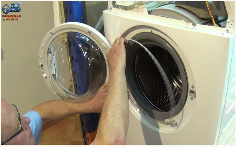 Tháo 2 con ốc vít ở cửa máy giặt ra khỏi thành máy giặt electrolux